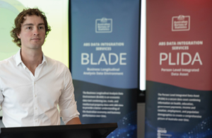 Man presenting in front of BLADE and PLIDA banners